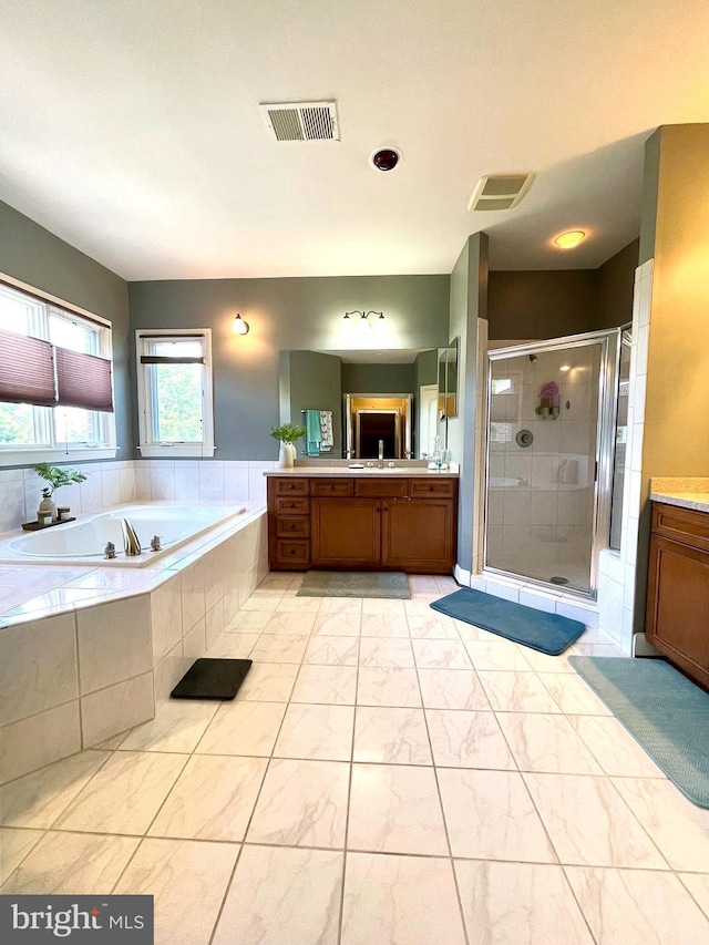 bathroom with a stall shower, a garden tub, and vanity
