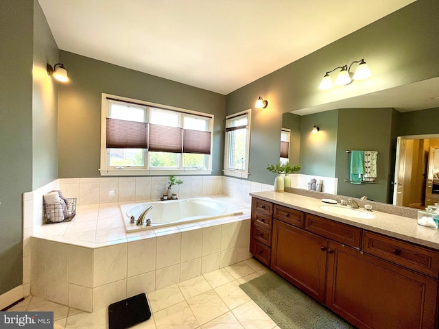 bathroom with a bath, vanity, and marble look tile flooring