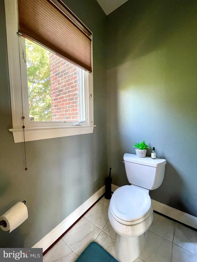bathroom featuring toilet, baseboards, and tile patterned flooring