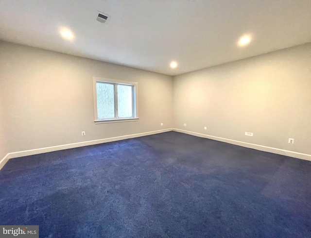 spare room with baseboards, recessed lighting, and dark colored carpet