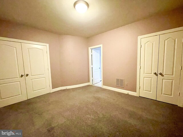 unfurnished bedroom with carpet, a closet, and baseboards