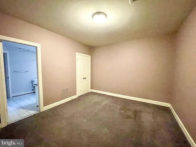 carpeted empty room featuring baseboards