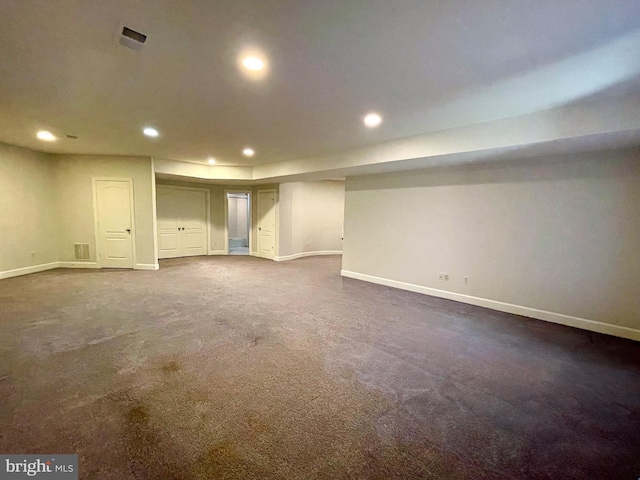 finished below grade area featuring baseboards, recessed lighting, and dark colored carpet