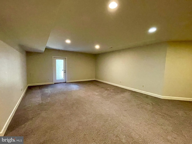 empty room with dark colored carpet, baseboards, and recessed lighting