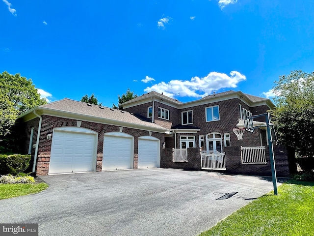 view of front of property featuring a garage, brick siding, and driveway
