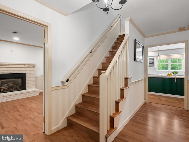 51 Seminary Rd, Glenmoore, PA 19343 - staircase with crown molding, wood finished floors, wainscoting, a fireplace, and a chandelier