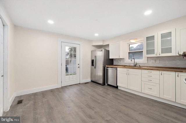 8422 Newark Rd, Newark, MD 21841 - kitchen featuring a sink, wooden counters, stainless steel appliances, glass insert cabinets, and light wood finished floors