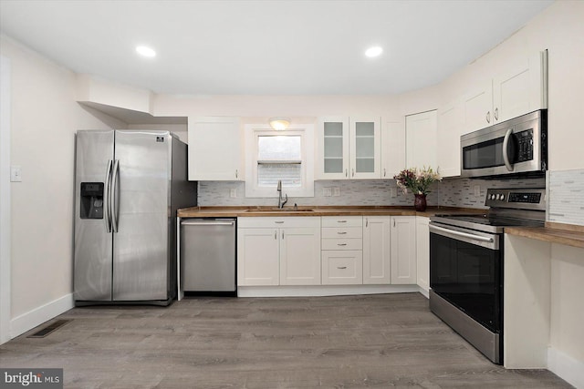 8422 Newark Rd, Newark, MD 21841 - kitchen featuring appliances with stainless steel finishes, a sink, wooden counters, tasteful backsplash, and white cabinetry