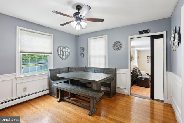 430 W Palmer St, Morrisville, PA 19067 - dining space featuring baseboard heating, a wainscoted wall, a ceiling fan, breakfast area, and light wood finished floors