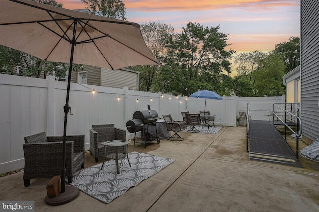 430 W Palmer St, Morrisville, PA 19067 - patio terrace at dusk featuring outdoor dining area, a fenced backyard, and a grill