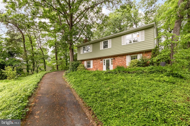 6008 Hawthorne St, Cheverly, MD 20785 - colonial-style house featuring asphalt driveway, brick siding, and a chimney