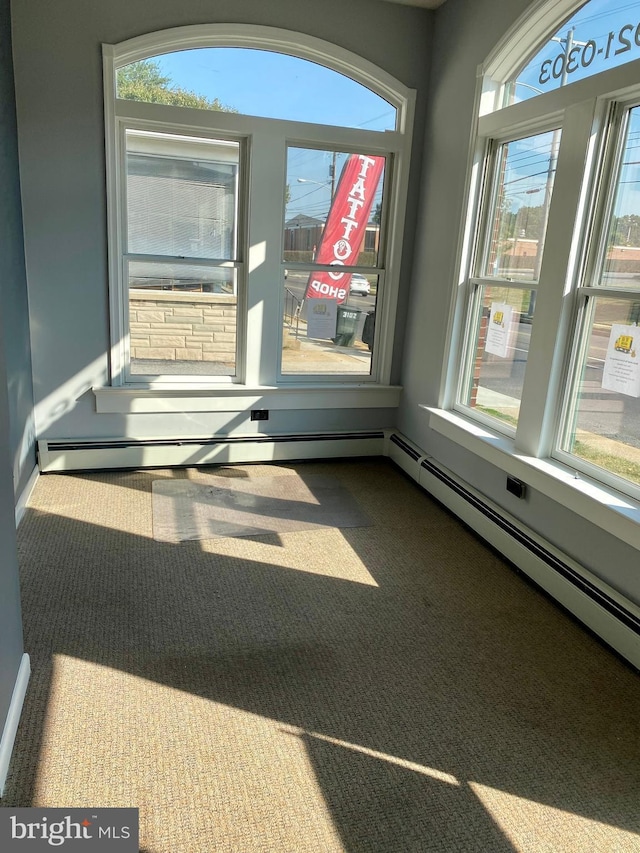 spare room featuring dark colored carpet and baseboard heating