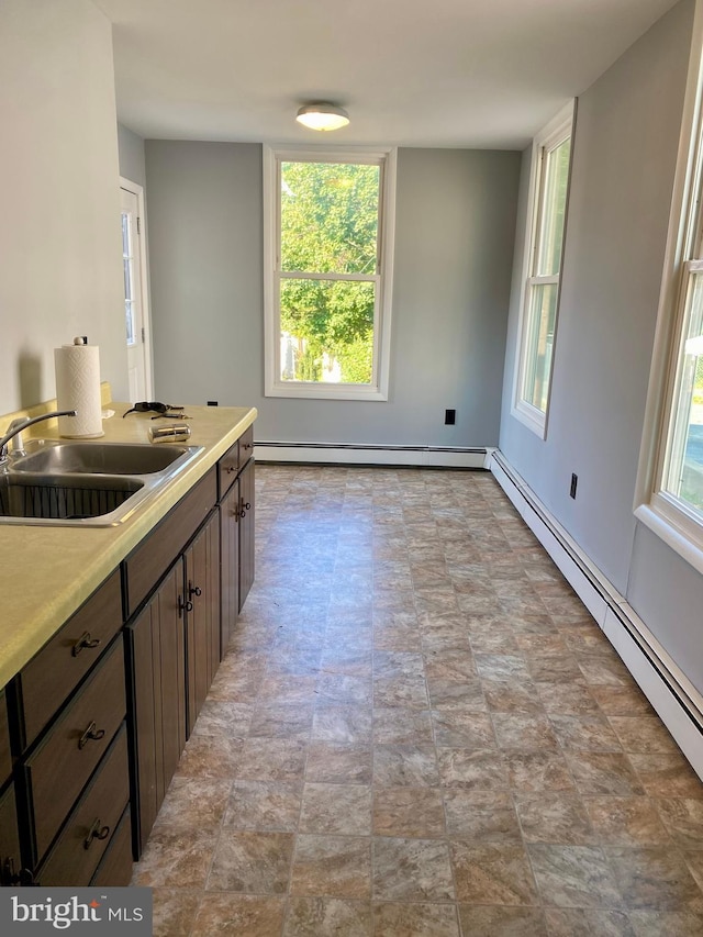 kitchen with a sink, a baseboard radiator, and light countertops
