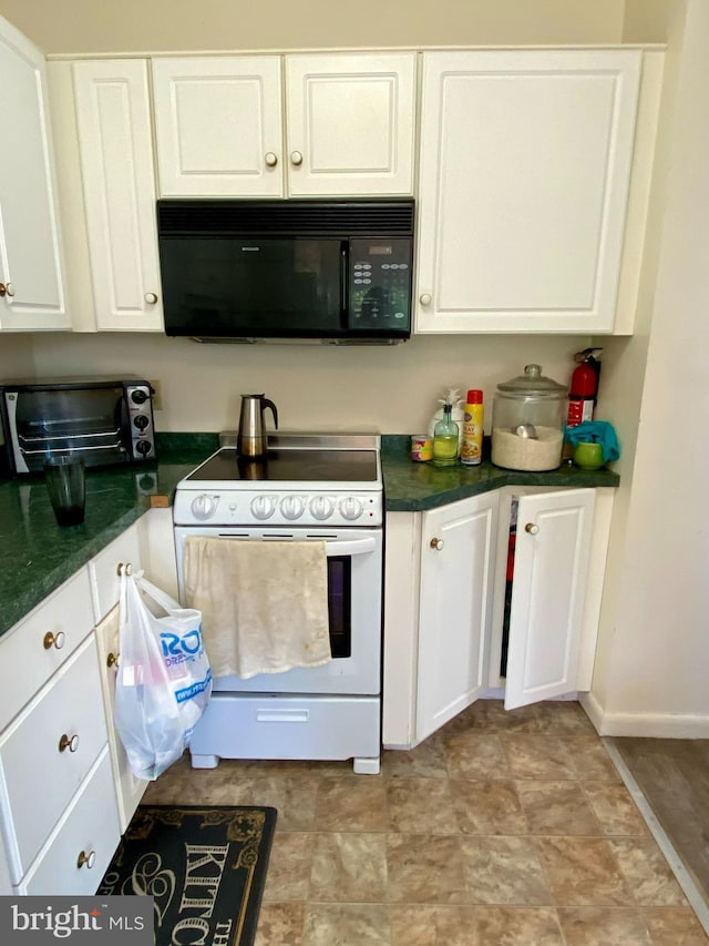 kitchen featuring black microwave, white range with electric cooktop, dark countertops, and white cabinets