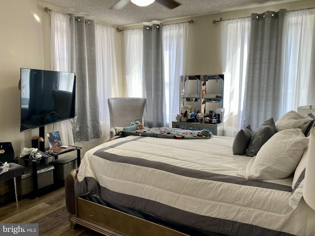 bedroom featuring a textured ceiling, wood finished floors, and a ceiling fan