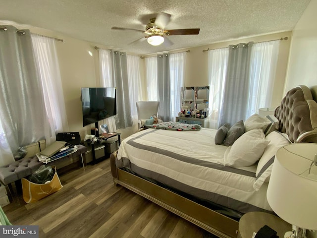 bedroom featuring wood finished floors, a textured ceiling, and ceiling fan