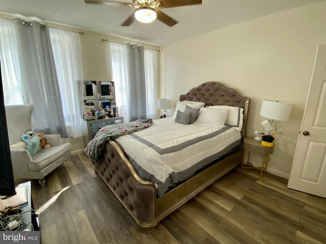bedroom featuring wood finished floors, a textured ceiling, baseboards, and a ceiling fan