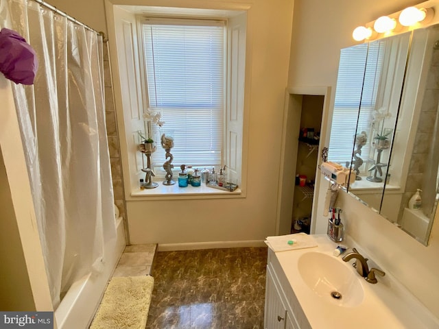 bathroom featuring vanity, baseboards, and shower / bath combination with curtain