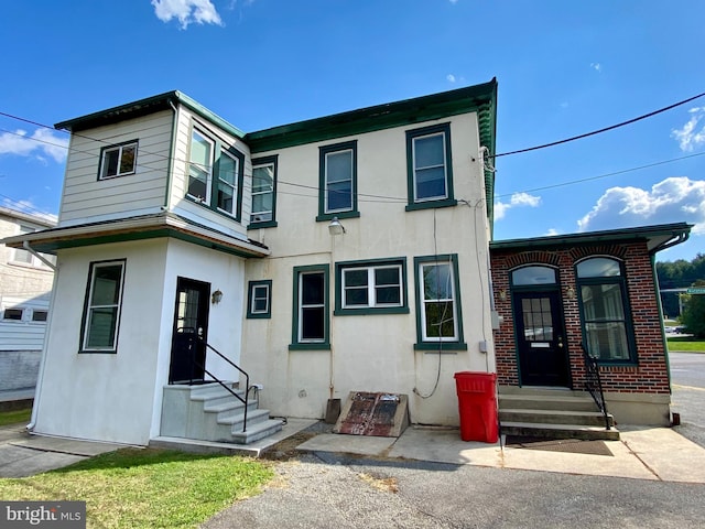 townhome / multi-family property with entry steps and stucco siding