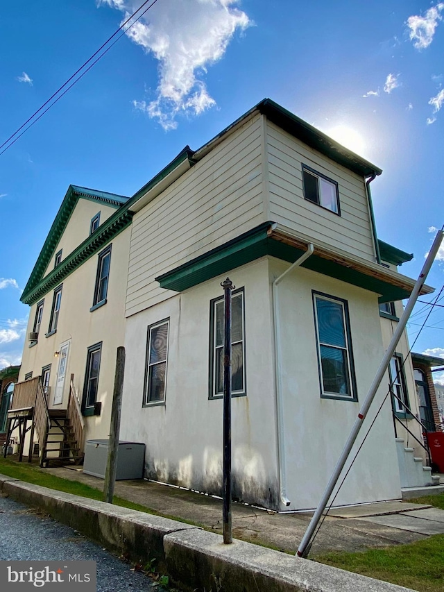 view of home's exterior with stucco siding and stairway