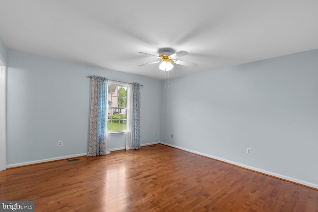 unfurnished room featuring ceiling fan, wood finished floors, and baseboards