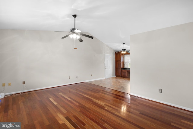 unfurnished room featuring ceiling fan, wood finished floors, vaulted ceiling, and baseboards