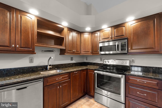 kitchen featuring appliances with stainless steel finishes, a sink, dark stone counters, open shelves, and recessed lighting