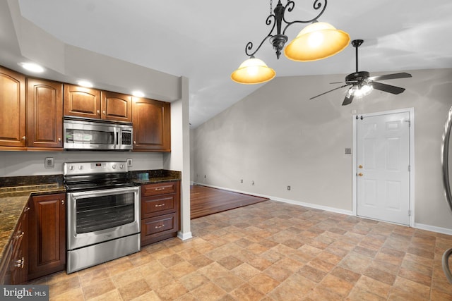 kitchen featuring stainless steel appliances, stone finish flooring, a ceiling fan, baseboards, and dark stone countertops