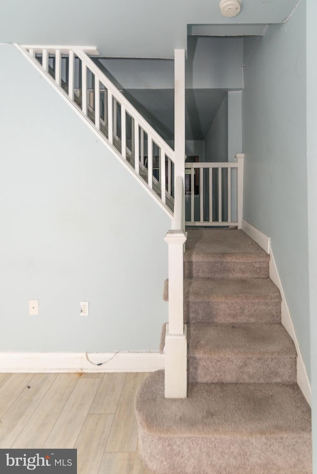 stairway featuring baseboards and wood finished floors