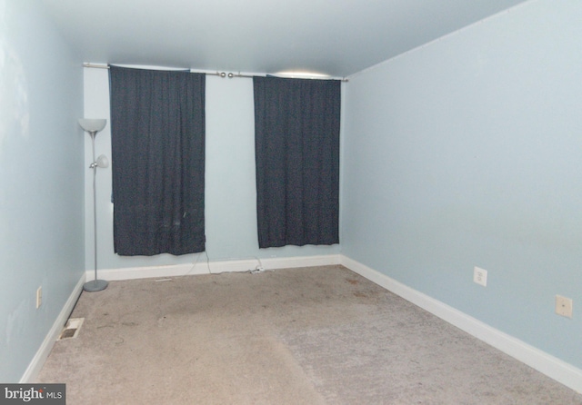 unfurnished room featuring carpet flooring and baseboards