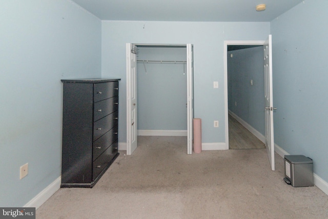 unfurnished bedroom featuring carpet, baseboards, and a closet