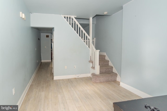 stairs with wood finished floors and baseboards