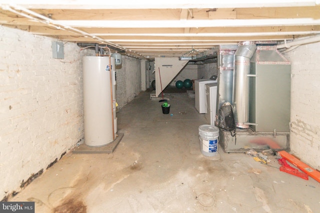 unfinished basement with water heater and washer / clothes dryer