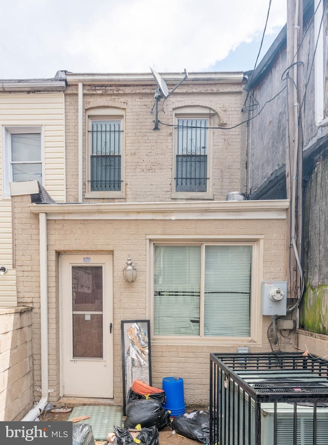 rear view of property with central AC unit and brick siding