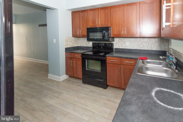 kitchen with black appliances, a sink, baseboards, tasteful backsplash, and light wood-type flooring
