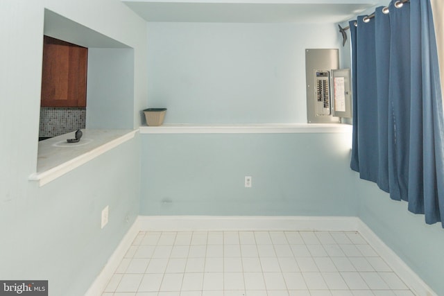 unfurnished room with electric panel, baseboards, and light tile patterned flooring