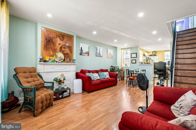 living room with stairs, light wood-type flooring, and recessed lighting
