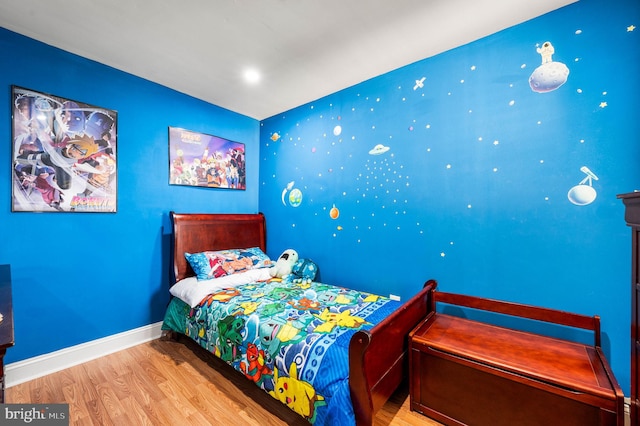 bedroom with wood finished floors and baseboards