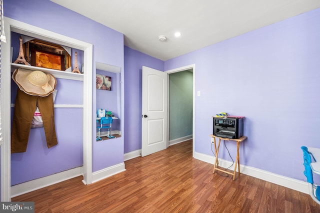 bedroom with wood finished floors, baseboards, and recessed lighting