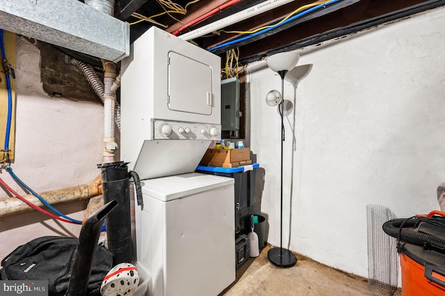 laundry room featuring stacked washer / dryer and electric panel