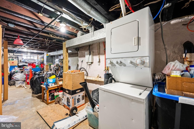 unfinished below grade area with stacked washer and clothes dryer