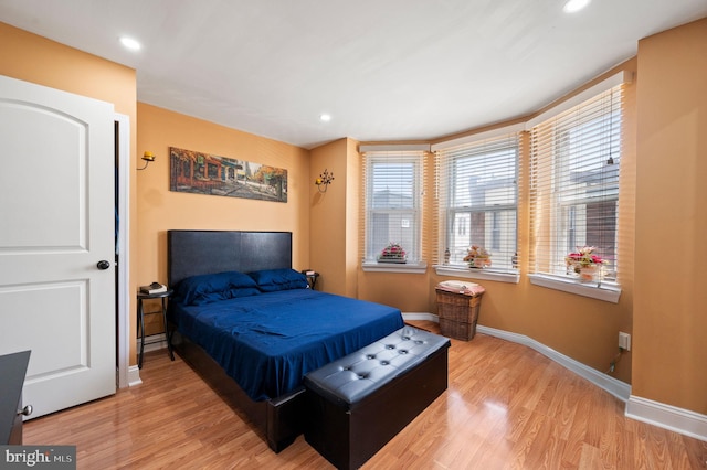 bedroom with wood finished floors, baseboards, and recessed lighting