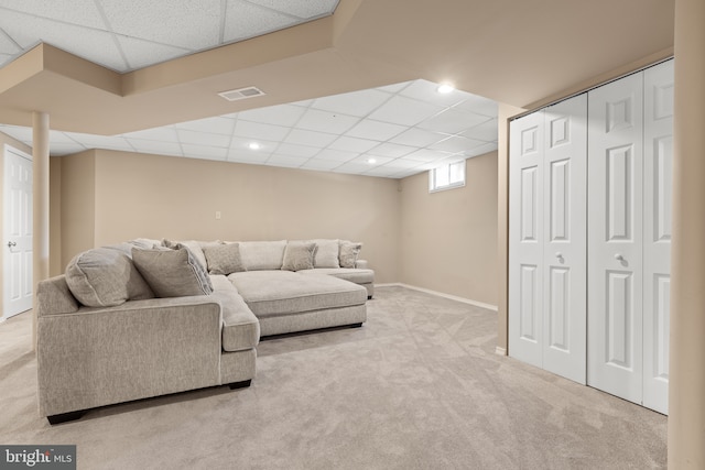 carpeted living area featuring a paneled ceiling, recessed lighting, and baseboards