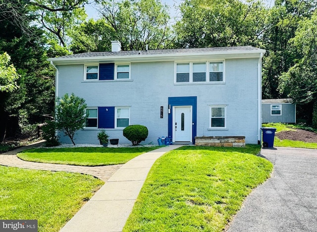6415 Wilcox Ct, Alexandria, VA 22310 - view of front of house featuring brick siding, a front yard, and a chimney