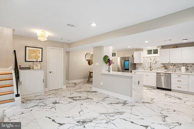 6415 Wilcox Ct, Alexandria, VA 22310 - kitchen featuring appliances with stainless steel finishes, white cabinets, light countertops, decorative backsplash, and glass insert cabinets