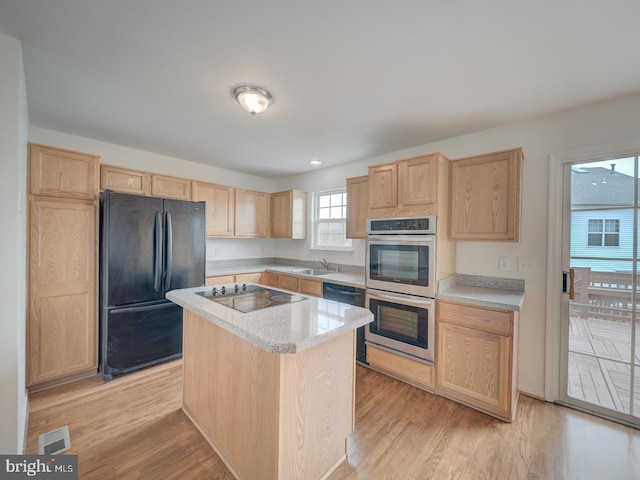 13195 Golders Green Pl, Bristow, VA 20136 - kitchen with black appliances, light brown cabinetry, light countertops, and a kitchen island
