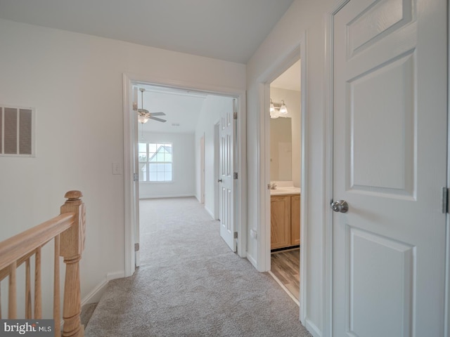 13195 Golders Green Pl, Bristow, VA 20136 - hallway with light colored carpet, baseboards, an upstairs landing, and a sink