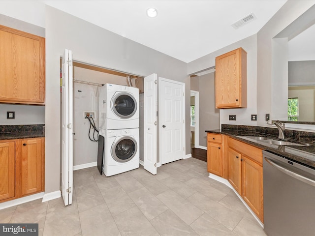 washroom featuring stacked washing machine and dryer and baseboards