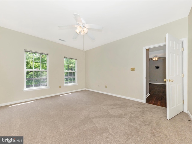 spare room with ceiling fan, carpet, and baseboards