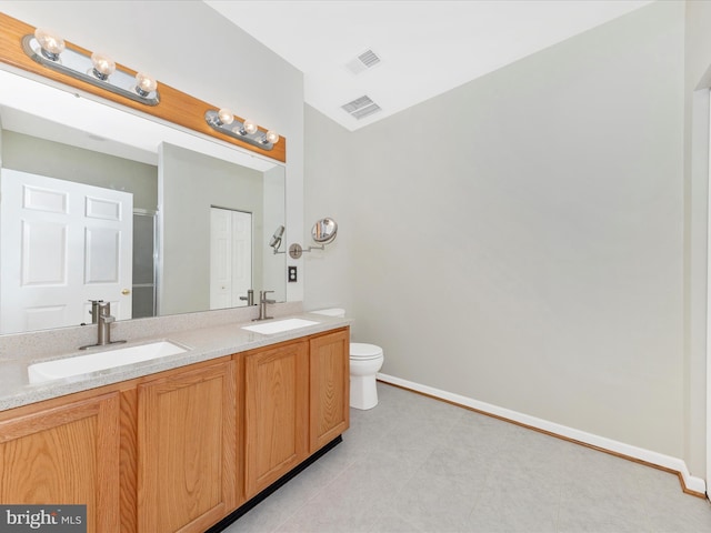 bathroom featuring double vanity, baseboards, toilet, and tile patterned floors